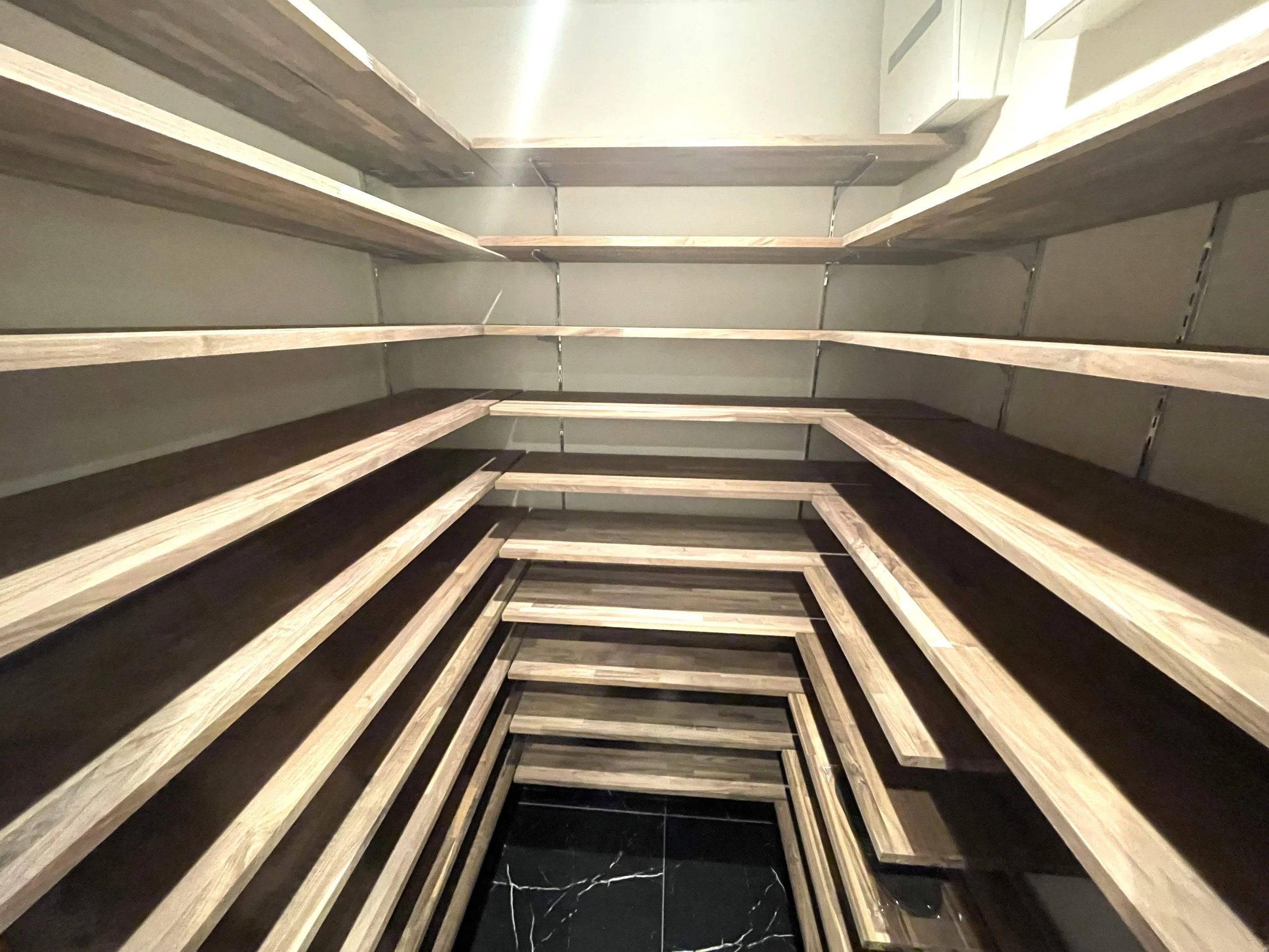 木製の棚が階段のように配置された狭い部屋の内側から撮影した写真