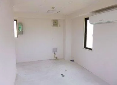 空の部屋で、壁に窓とエアコンがある