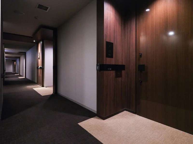 ホテルの廊下とエレベーターホールのドア。壁とドアは木製仕上げ。