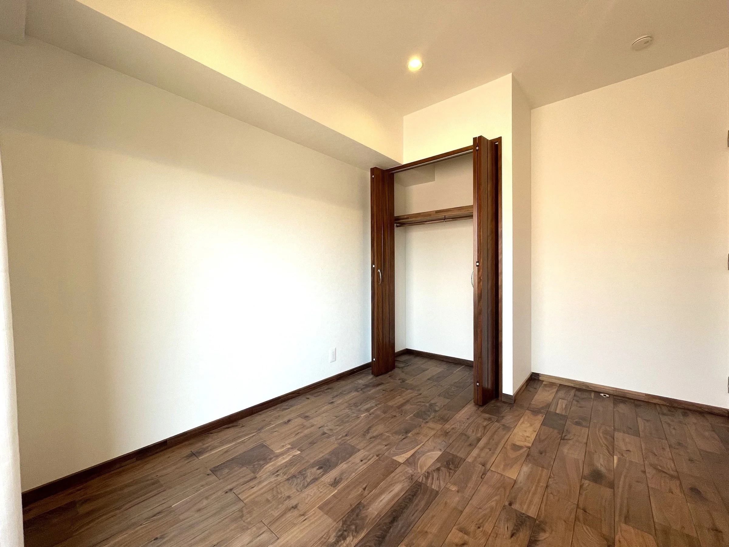 木製の床と白い壁の部屋、萎んだ扉。