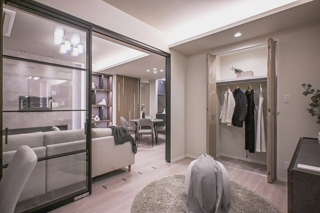 リビングルームとダイニングエリアのある現代的なインテリアの居住空間、クローゼットと収納空間も見える