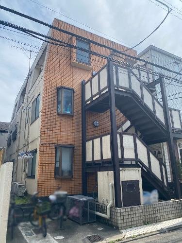 3階建てのレンガ造りのアパートメントの建物と外階段