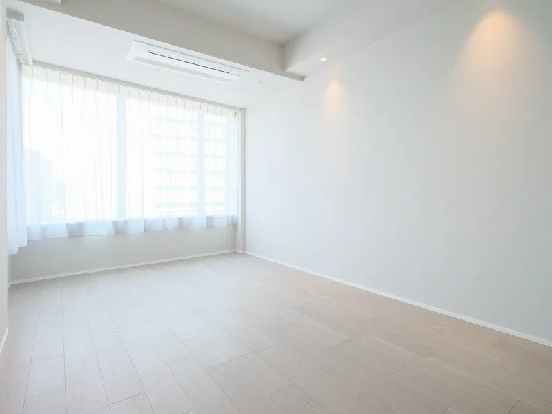 明るい白い壁と大きな窓がある空っぽの部屋
