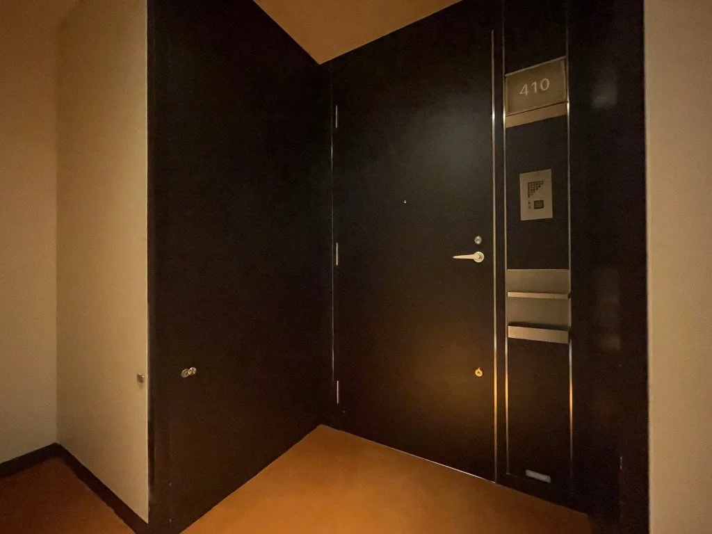 ホテルの部屋のエントランス、扉とインターホンや棚の付いた壁面が見える