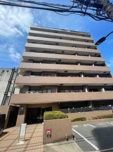 多層のマンションの外観と青空