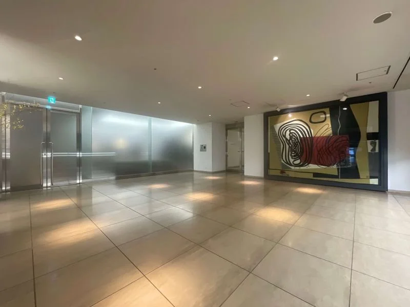 抽象画が展示された、ガラス扉のある明るい modern な屋内ロビー