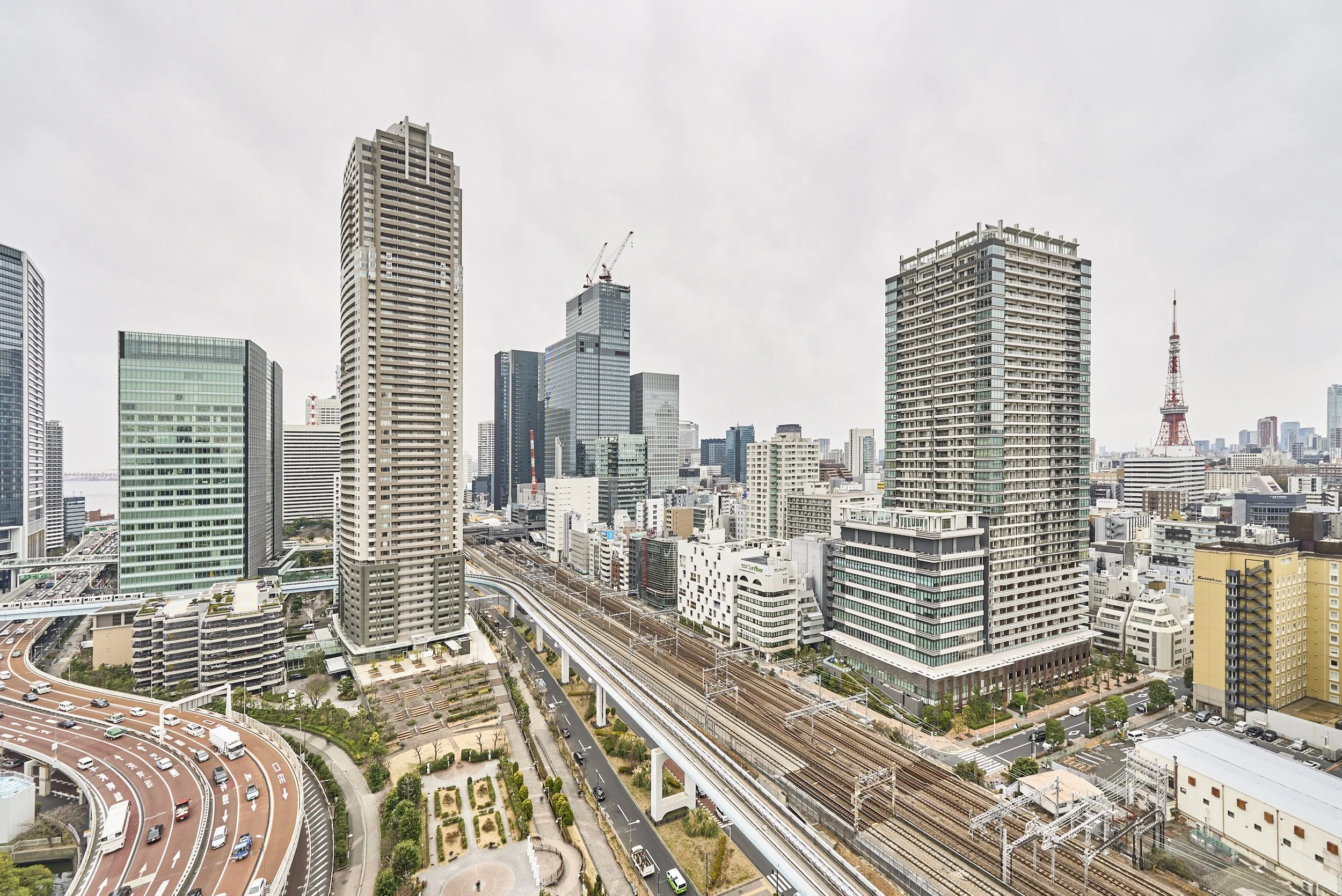 高層ビルと道路、鉄道が交差する都会の景色。