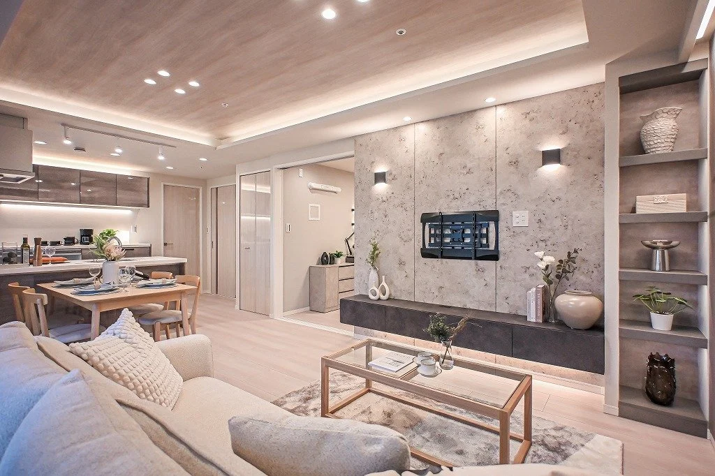 モダンなリビングルームの interior, ソファ、コーヒーテーブル、壁掛けテレビ、飾り棚と装飾品。ダイニングエリアとキッチンも見える