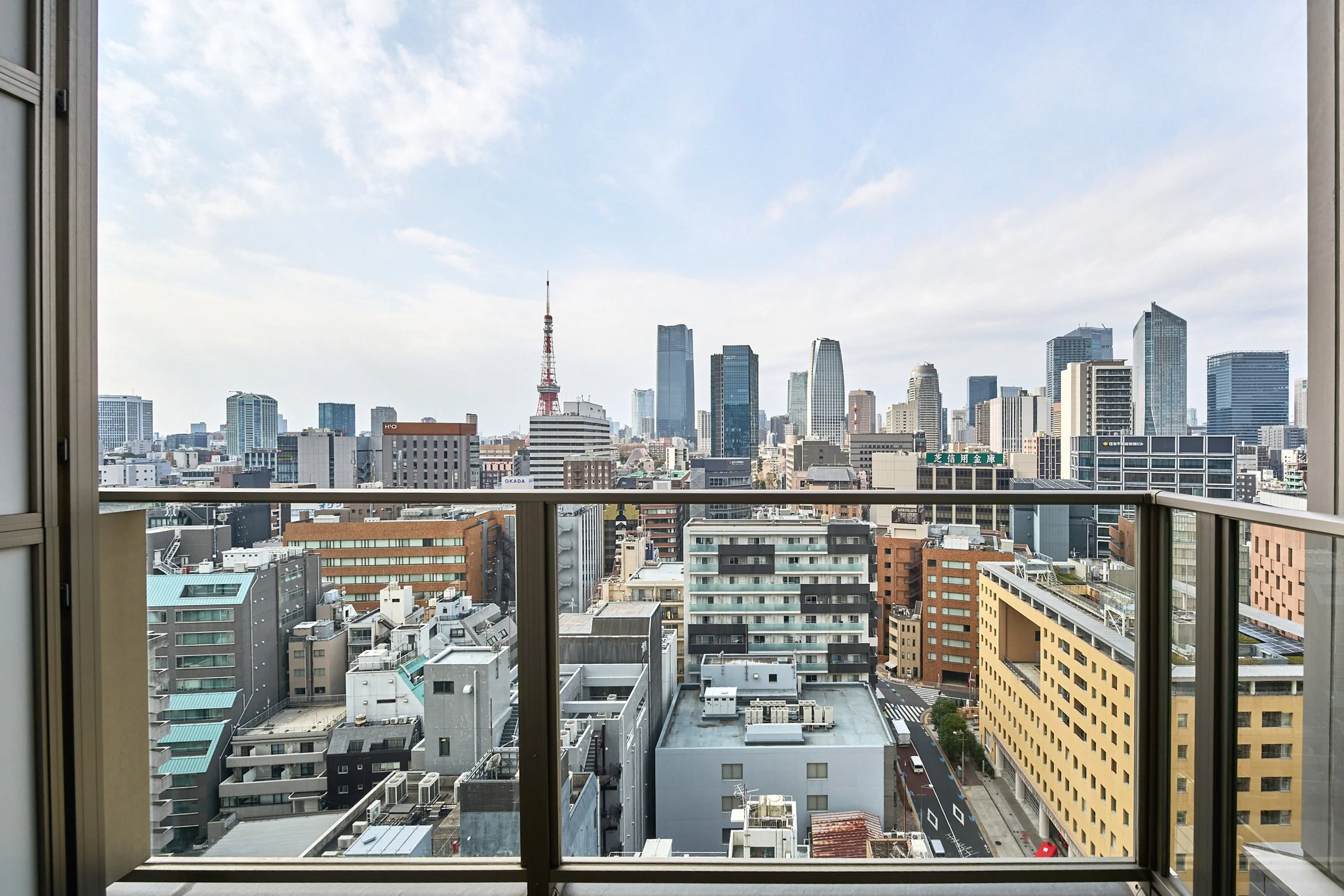 高層ビルと東京タワーが見える都市の景色を窓越しに捉えた写真