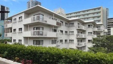 白い多層建築のアパートメントと緑の生垣