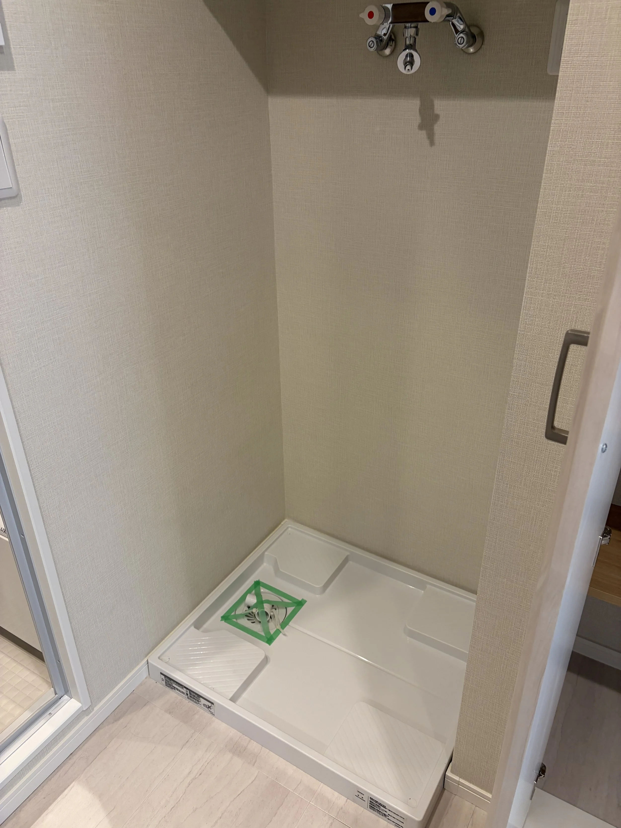 洗濯機置き場、洗濯機の排水スペースと蛇口があります。