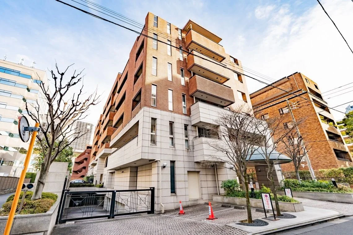 都市の高層アパートメントビルと通りの景色。木とフェンス、交通 cones が見える