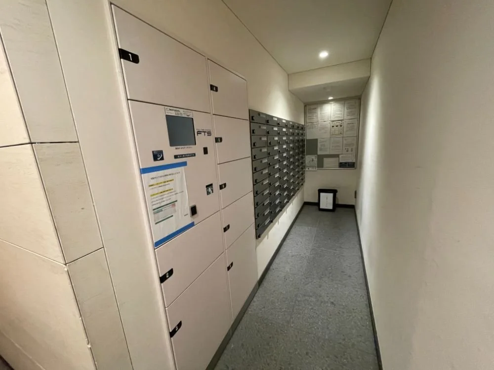 郵便受けと宅配ボックスが並んでいる共同郵便受けエントランスの通路