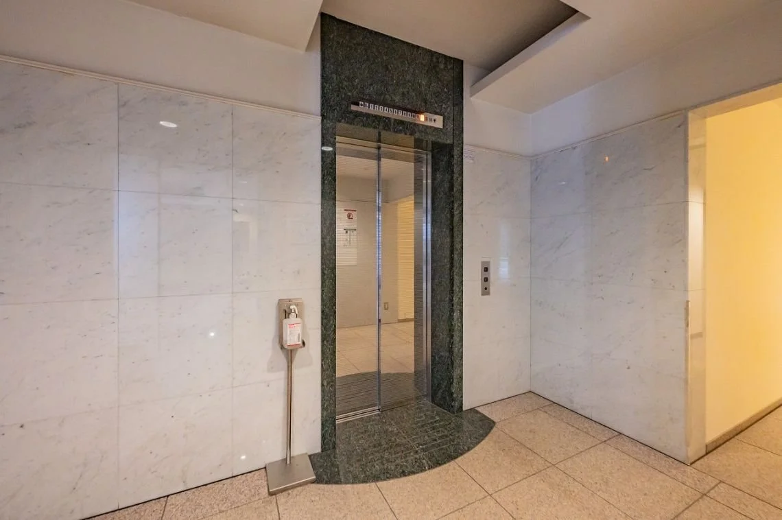 エレベーターのドアと壁、エレベーター呼び出しボタンがあるモールの廊下