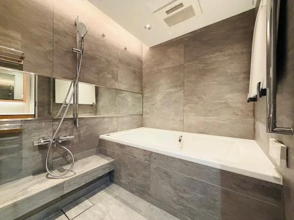 バスルームのシャワーと浴槽を備えたモダンな浴室画像。