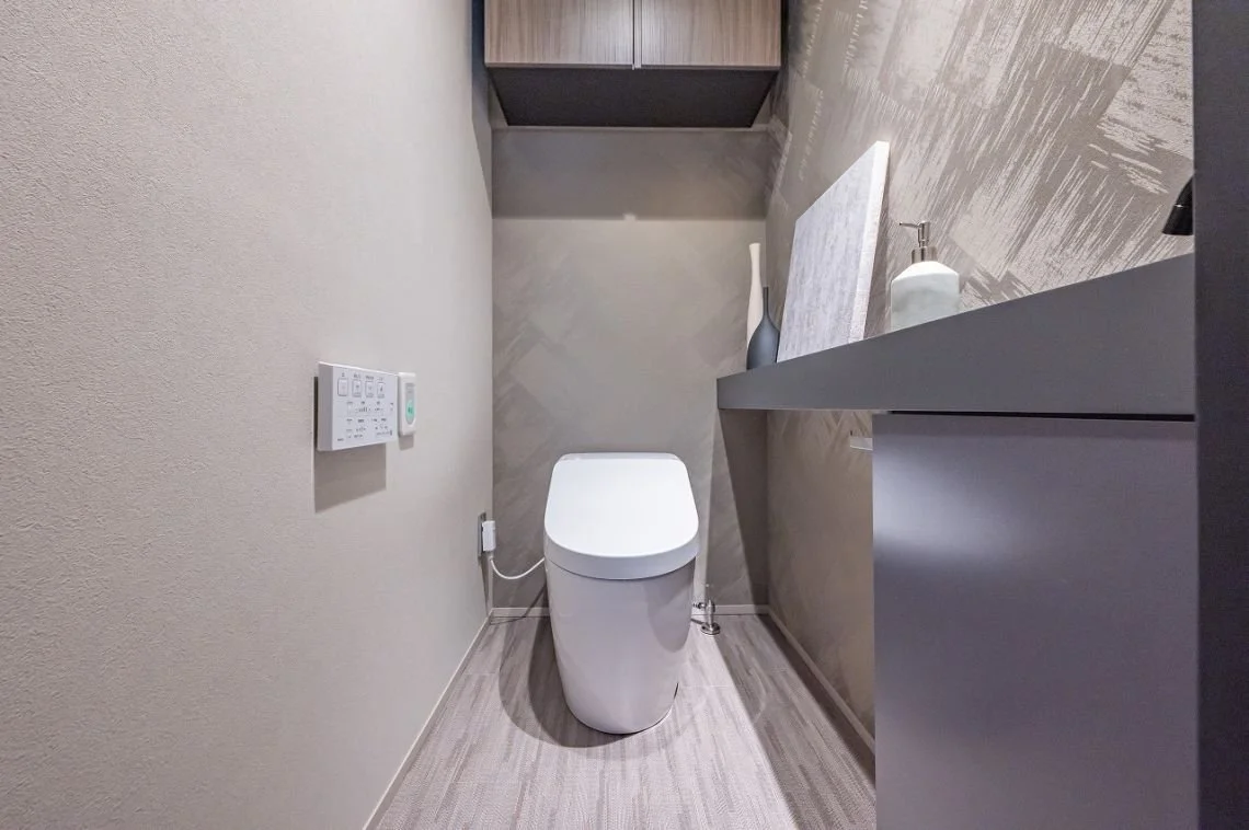 モダンなトイレと洗面台があるトイレルームの interior