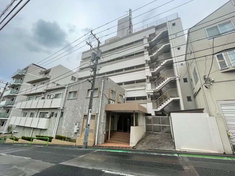 複数階建てのマンションと道路、電柱と電線