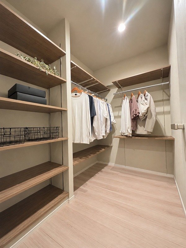 クローゼットの中に洋服と収納棚が置かれているシンプルな部屋.