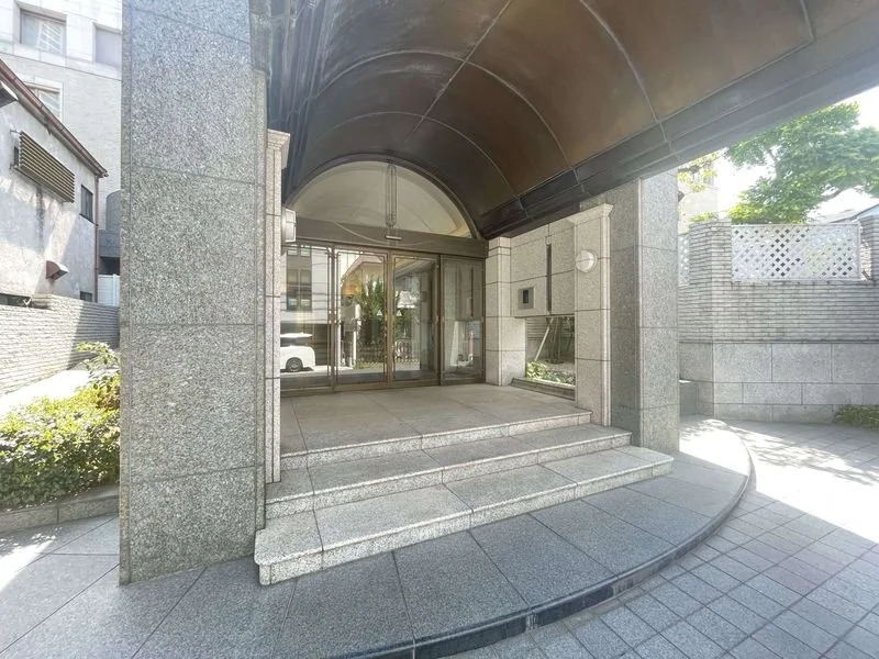 建物の入り口の階段と自動ドアとアーチ型の屋根