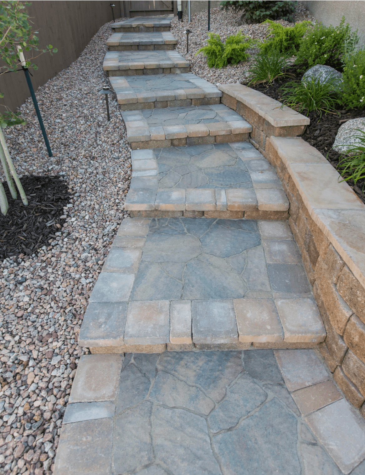 Custom stone retaining wall and paver steps with gravel walkway hardscaping by Top Turf in Boise Idaho Treasure Valley