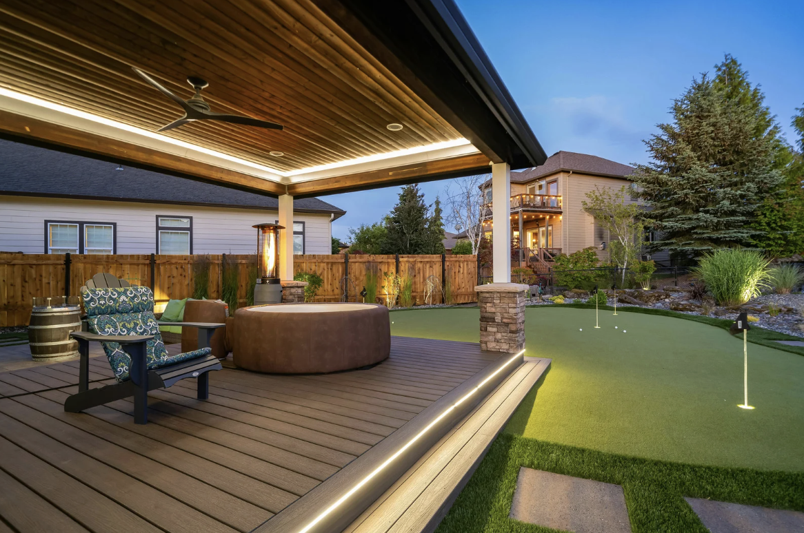 Luxury outdoor living space with covered wooden deck patio fire pit and artificial turf putting green by Top Turf in Boise Idaho