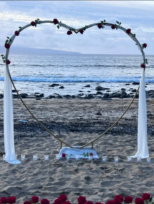 A custom heart shaped roses and rose petal arrangement designed on the beach in Maui for a surprise proposal and vow renewal. This romantic setup creates a stunning backdrop for unforgettable moments, whether you're planning a proposal, anniversary, 