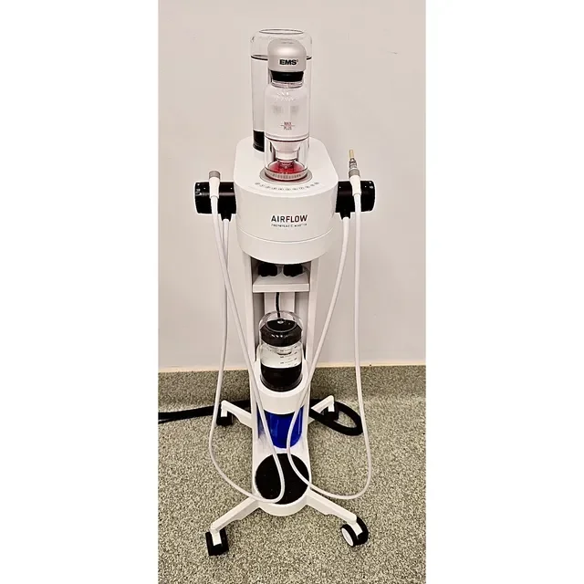 Medical device on a wheeled stand with tubes and canisters, labeled 'AIRFLOW', used for respiratory treatments.