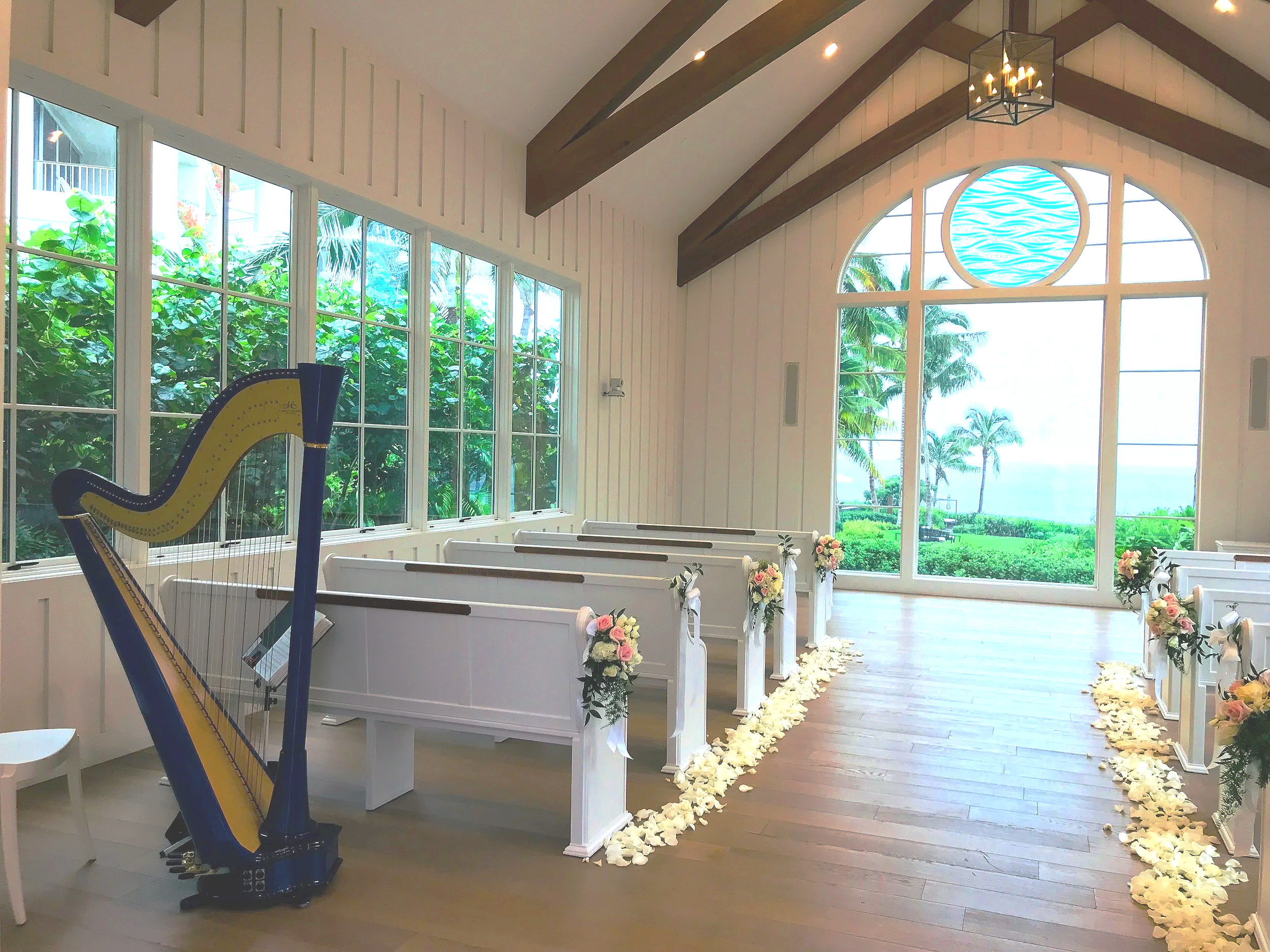 Inside a white chapel in a tropical setting with harp in the corner.