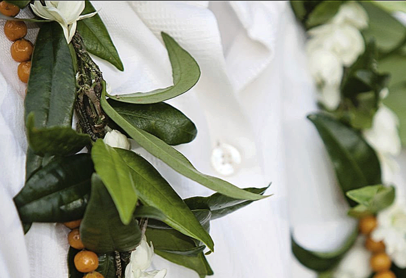 Maile lei with white flowers draped