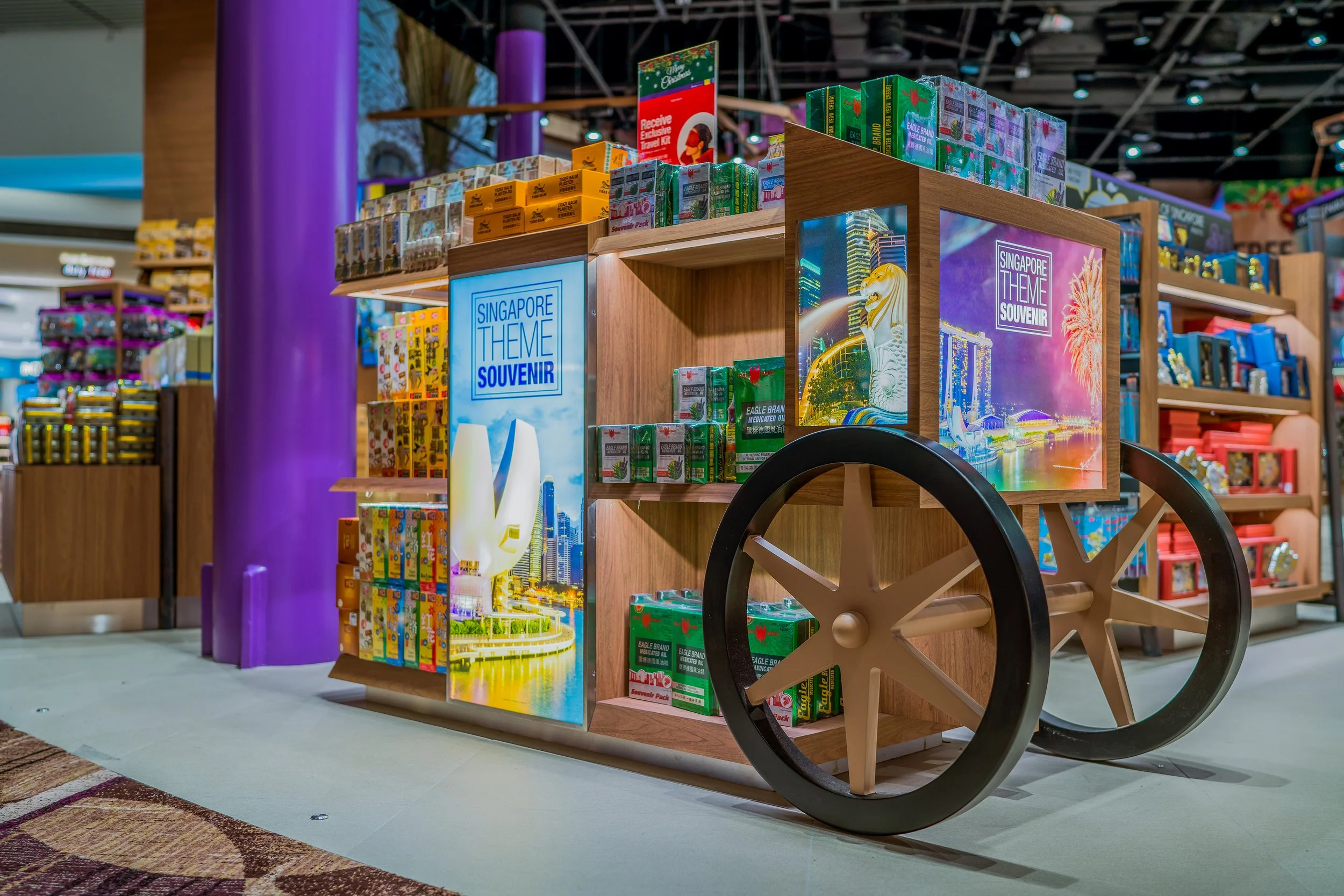 A souvenir cart in a retail store decorated with Singapore-themed displays and colorful souvenirs.