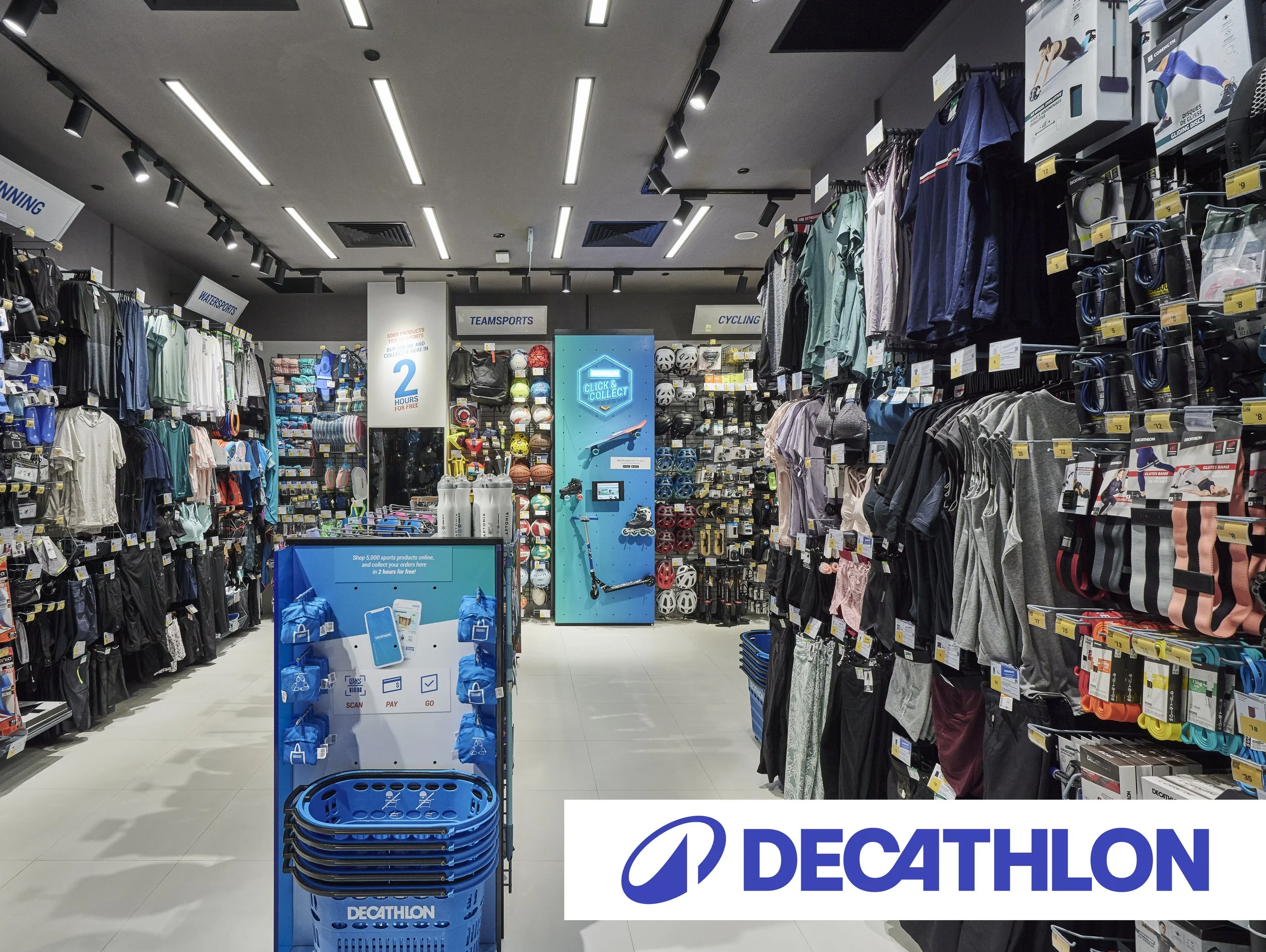 Interior view of a Decathlon sporting goods store with various sports equipment, clothing, and accessories on display, and a Decathlon logo at the front.