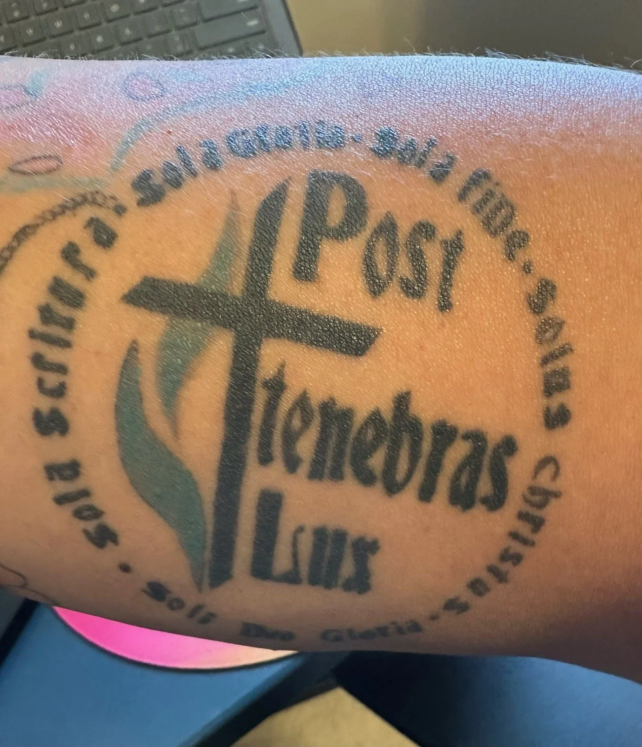Tattoo of the Torch of the Salvation Army with the words 'Post Temecula, LA' and the Salvation Army emblem on a person's arm.