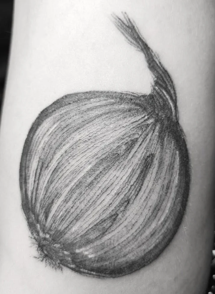 A realistic pencil drawing tattoo of an onion with detailed shading and texture.