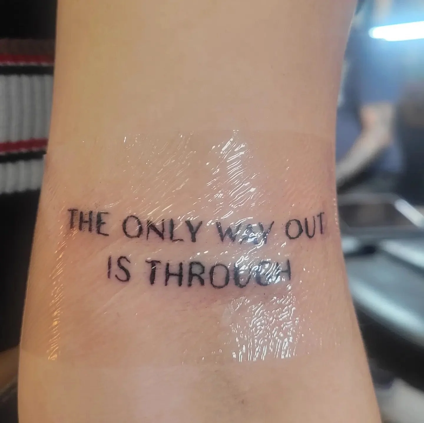 Tattoo on arm with the phrase 'The only way out is through'