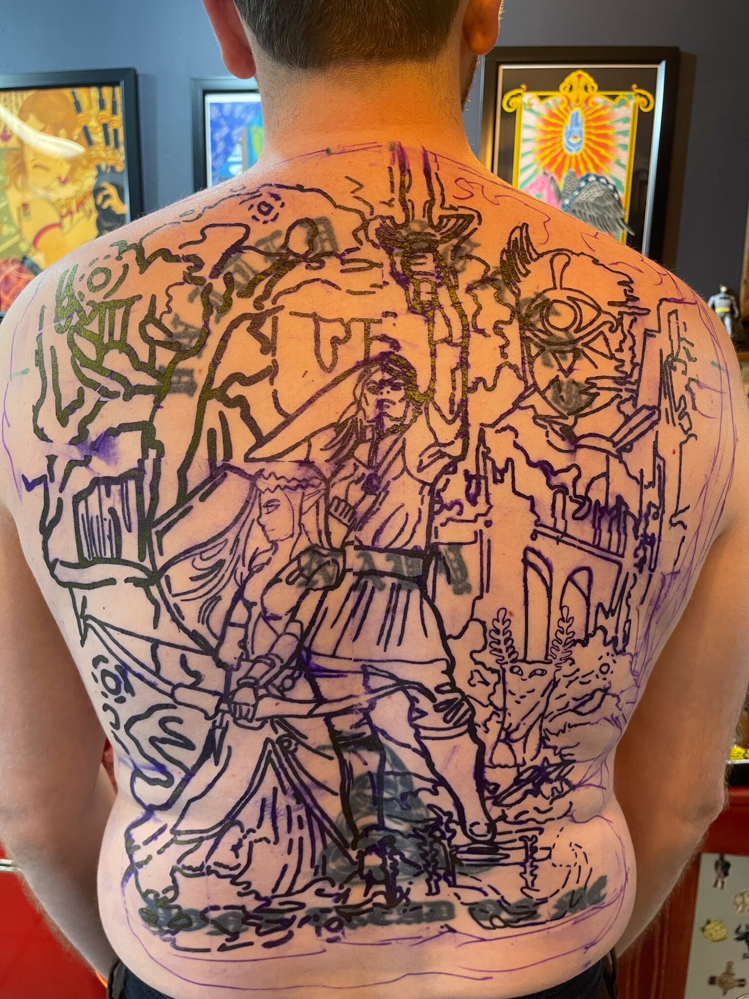 Tattoo outline on a person's back featuring a fantasy scene with a warrior, a girl, a deer with antlers, and various decorative elements.