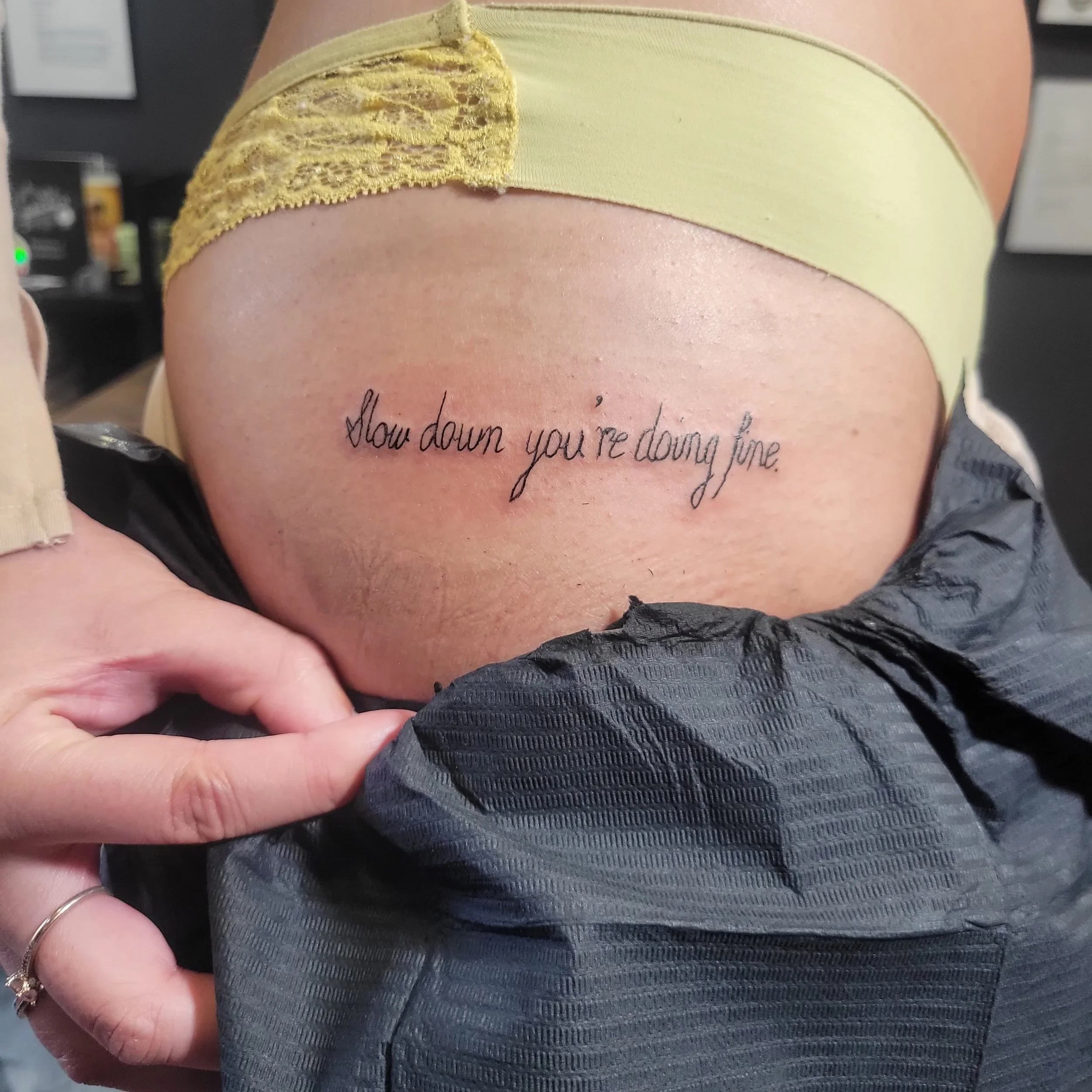 Tattoo on person's side reading, 'Slow down you're doing fine.'