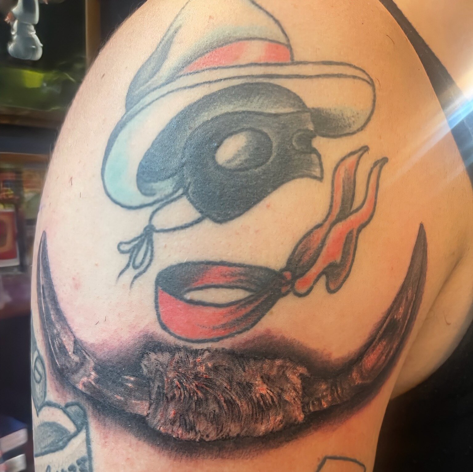 A interpretive Lone Ranger tattoo of his mask, hat and bandana, on a clients bicep.