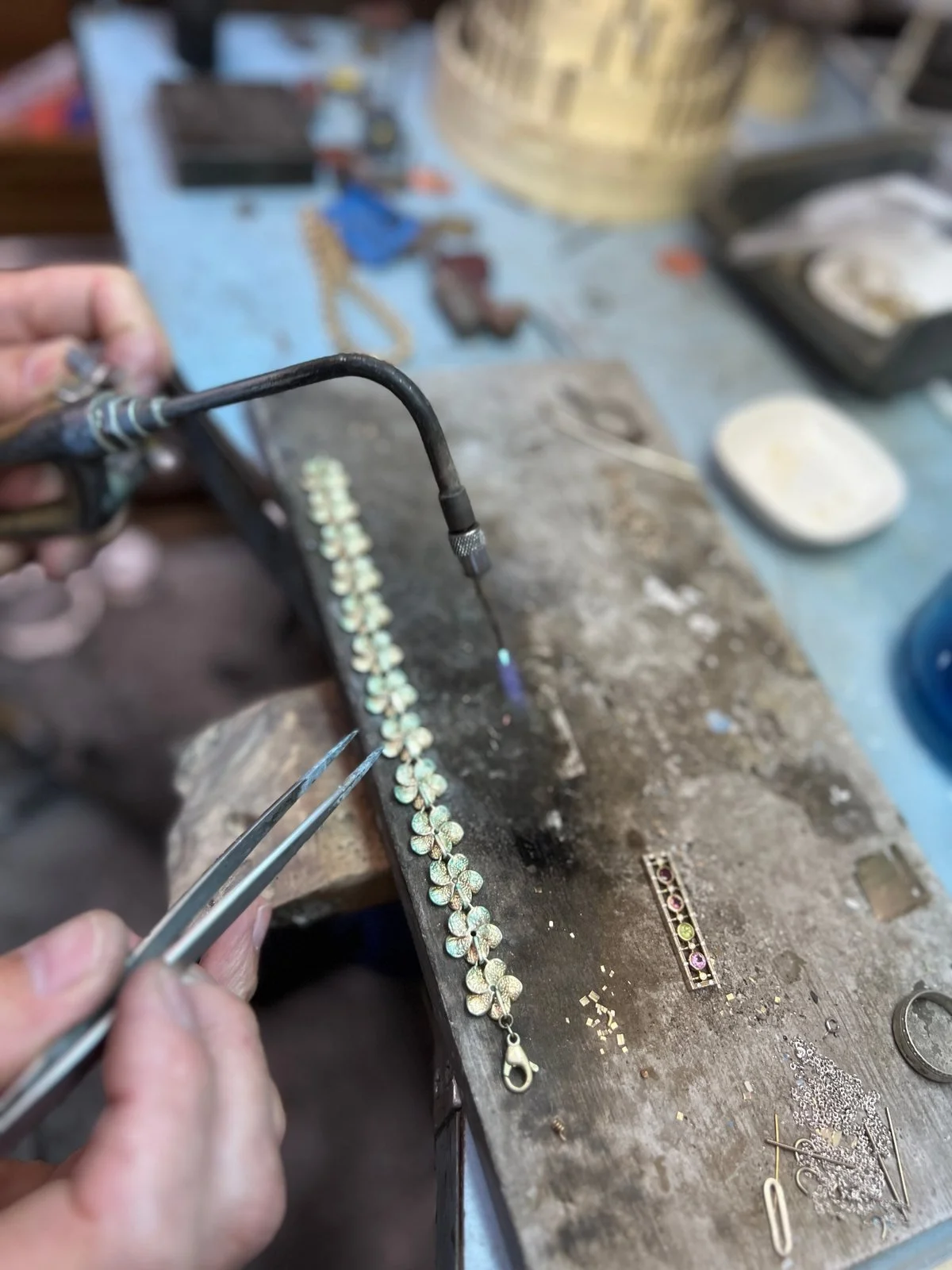 Gold bracelet being soldered and repaired by hand at the Kaz Jewelry bench in Laguna Niguel