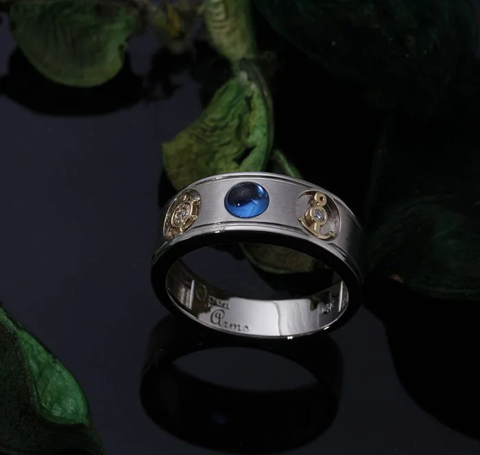 Custom men's wedding band with blue stone, ship's wheel and anchor details, satin center and high-polish edges, personal message engraved inside