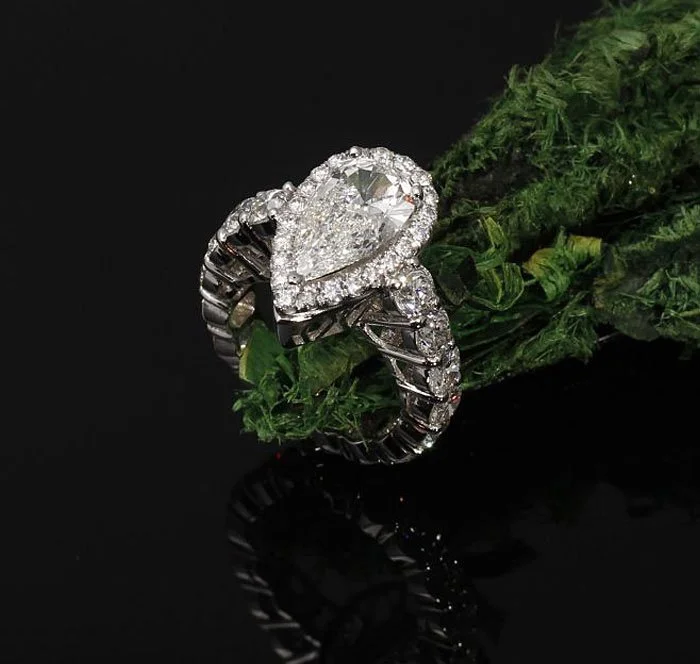 Round cut diamond halo engagement ring with pave-set diamonds on the band – custom crafted fine jewelry by Kaz Jewelry