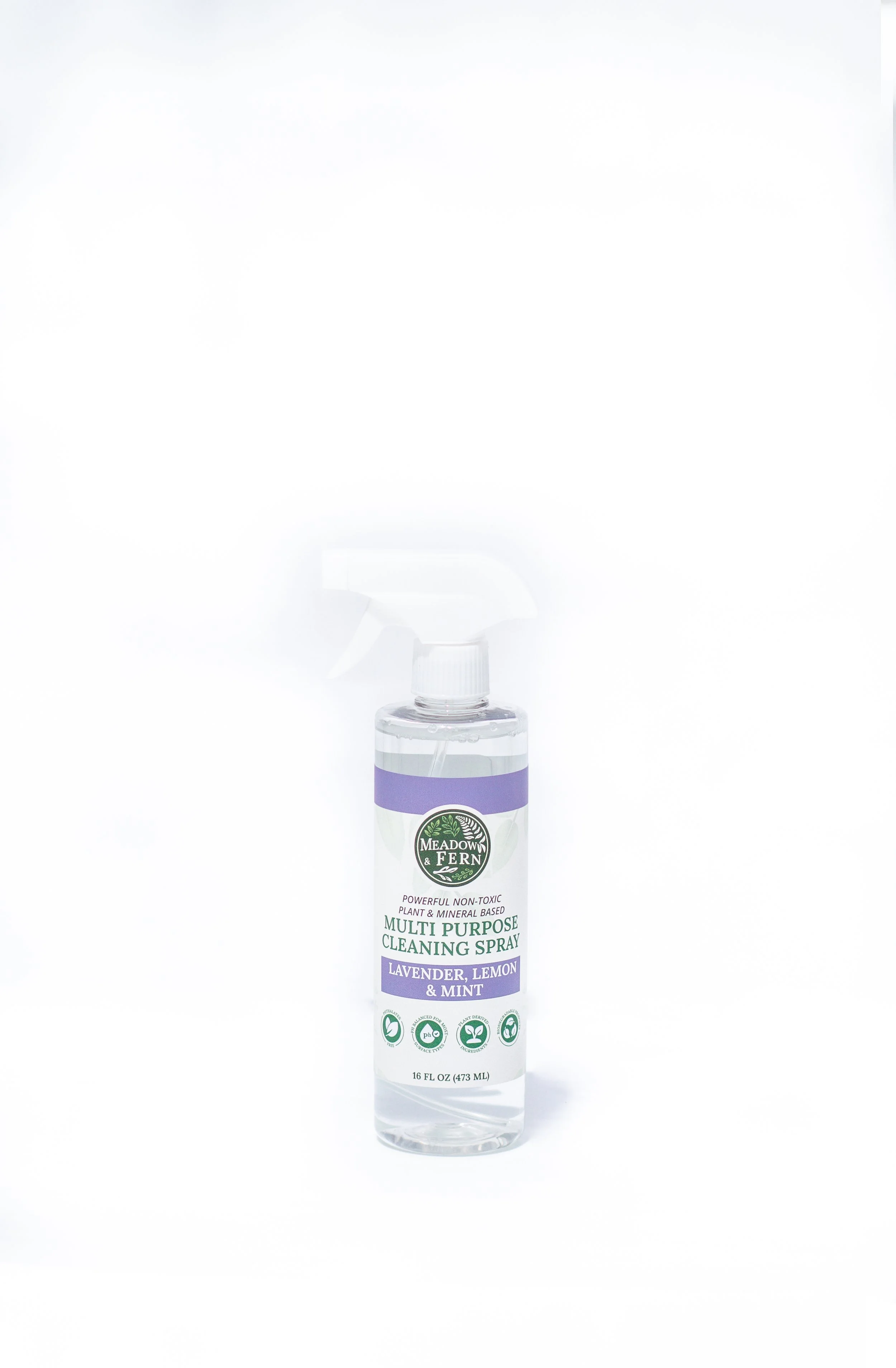 A clear spray bottle labeled Meadow & Fern Multi Purpose Cleaning Spray with lavender, lemon, and mint scent, standing upright on a white background.