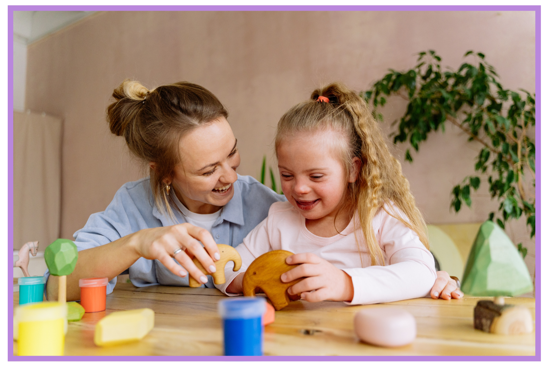 A woman and young girl playing with wooden and colorful toys at a table, learning, smiling and engaging with each other