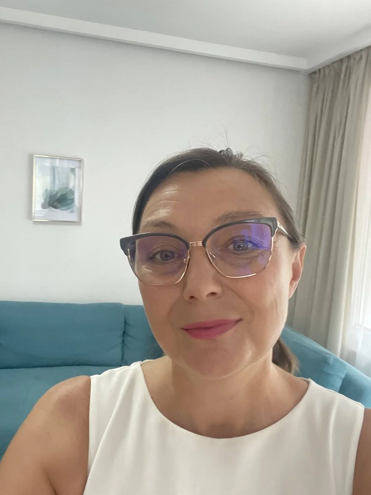 Жена с коса на кок, в бяла рокля и с очила. Клиент на бизнес навигатор Do Moments.