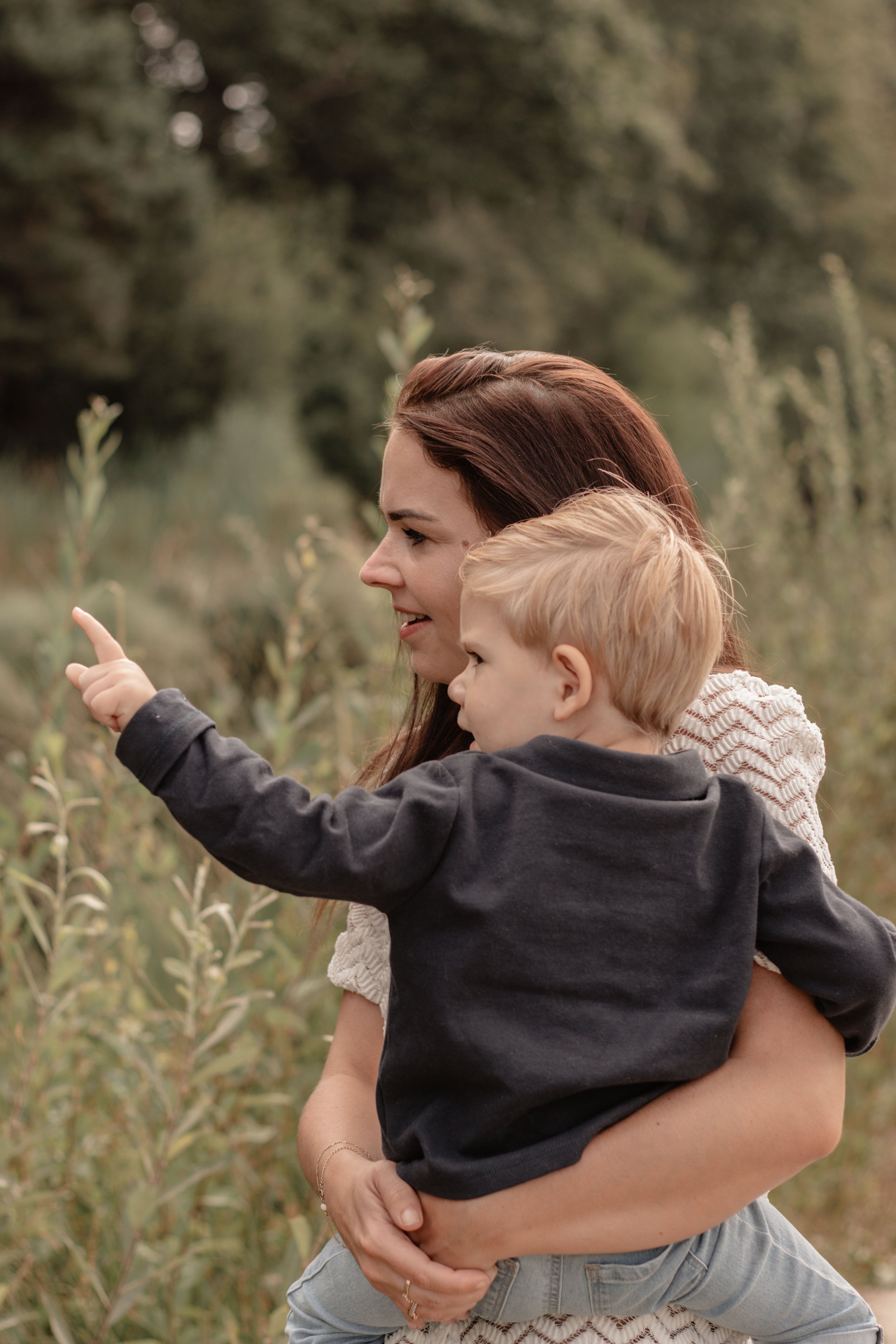 Zoontje wijst mama wat hij ziet. mama lacht