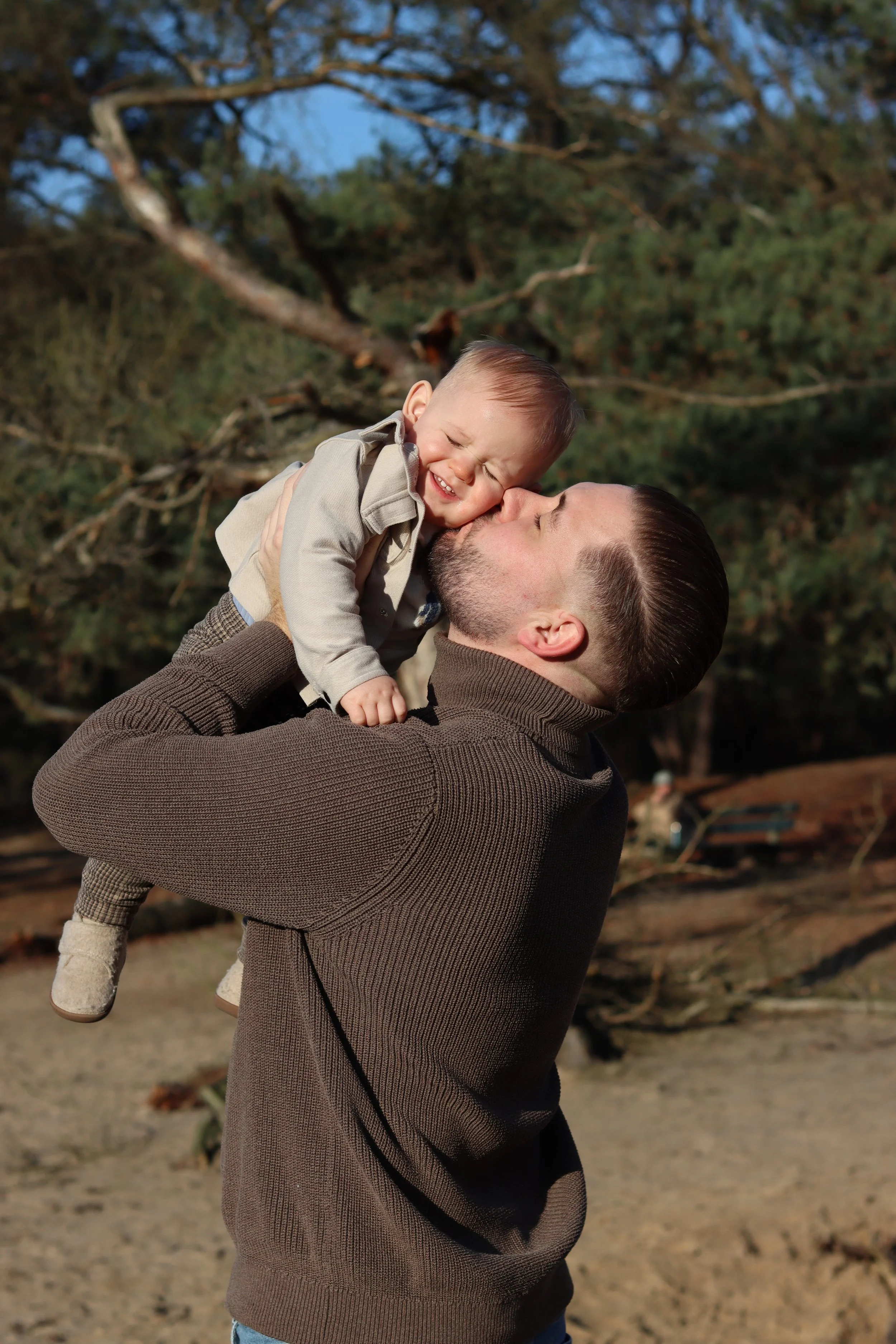 vader knuffelt zoon tijdens gezins fotoshoot familieshoot