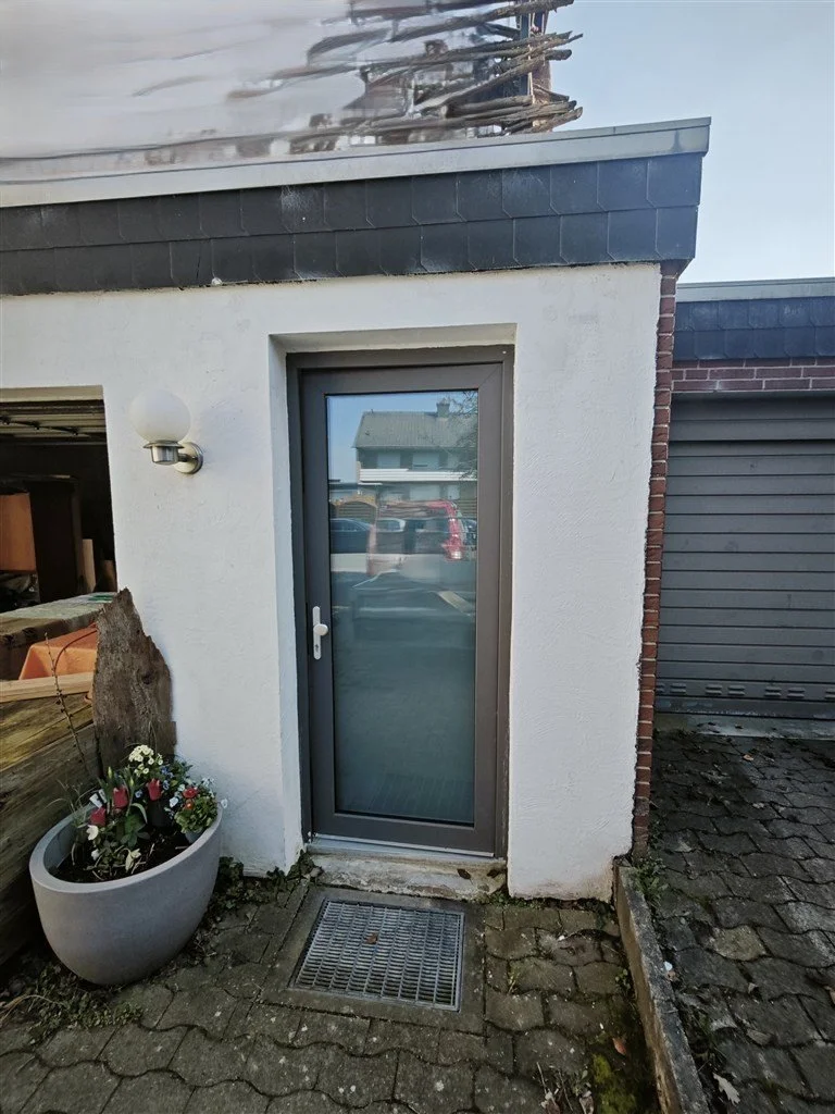 Ein Garagennebeneingang in Bielefeld mit einer neuen anthrazitfarbenen Glastür.