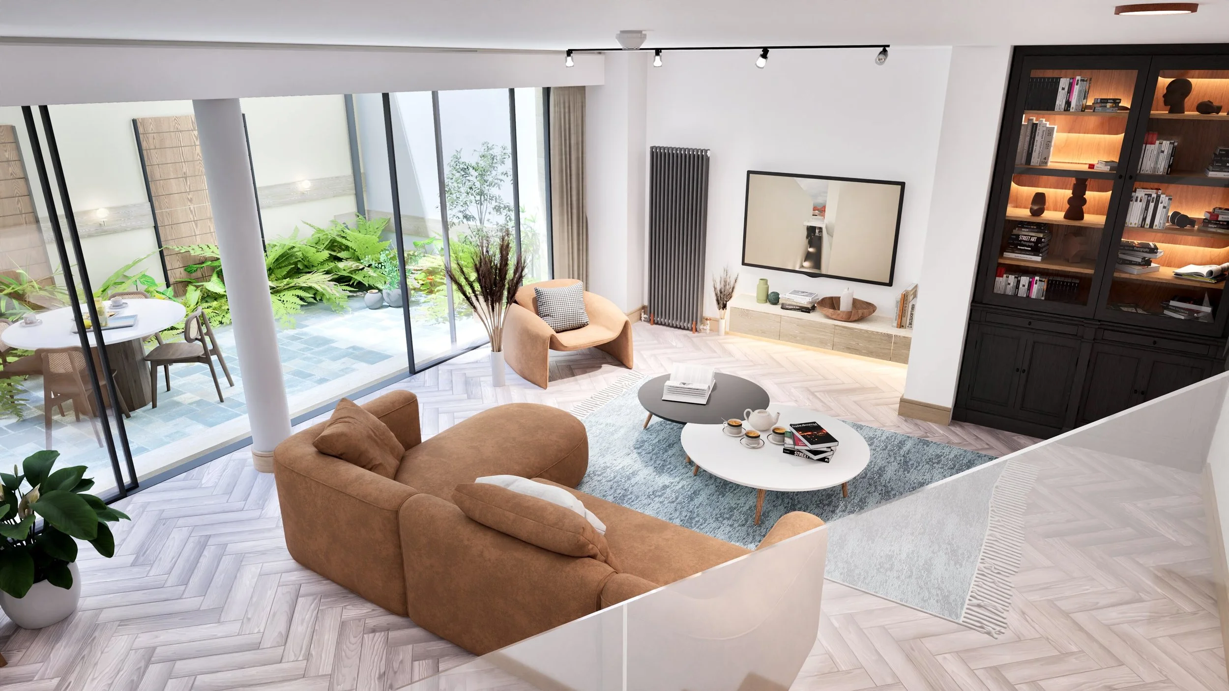 Modern living room with tan sofa, two oval coffee tables, beige armchair, large window with greenery outside, black bookcase, TV on white console, potted plant, and outdoor patio with a round table and chairs.