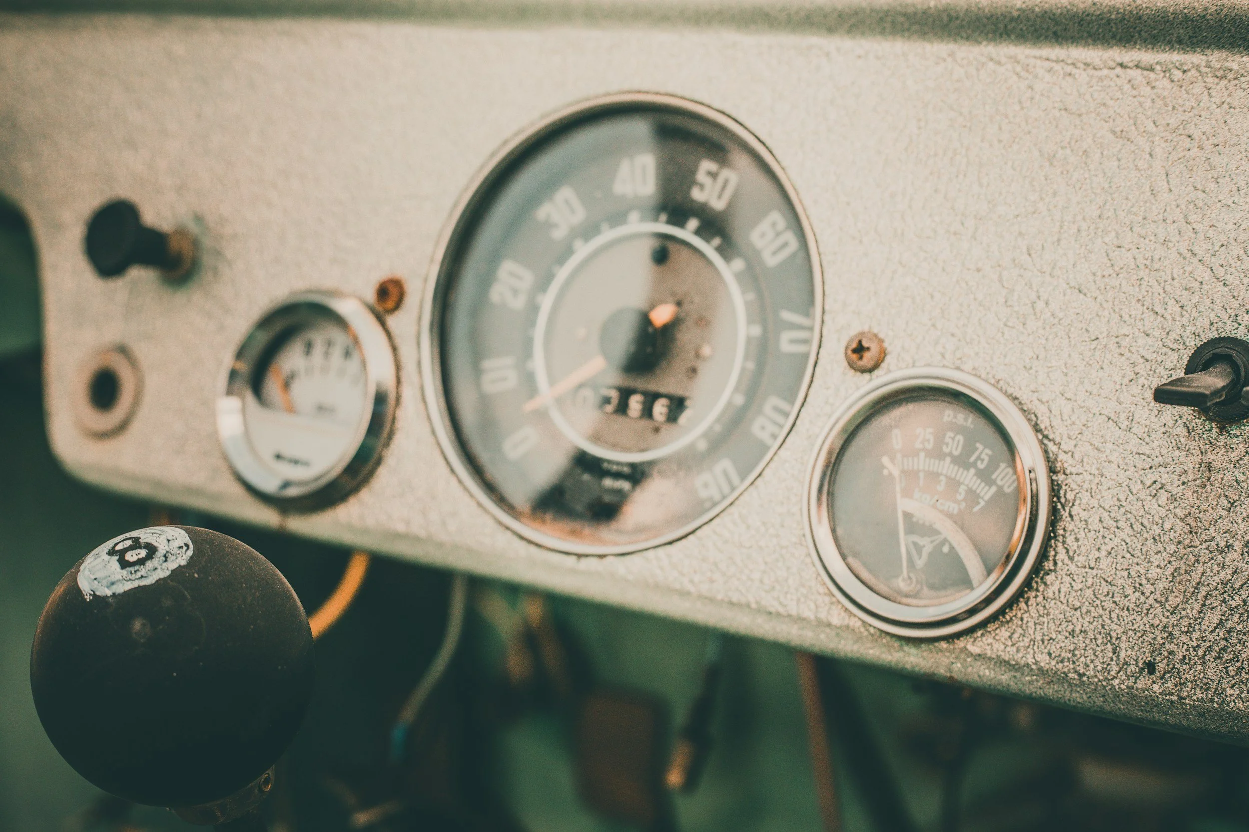 Close-up of a vintage car dashboard showing speedometer, fuel gauge, and oil pressure gauge.