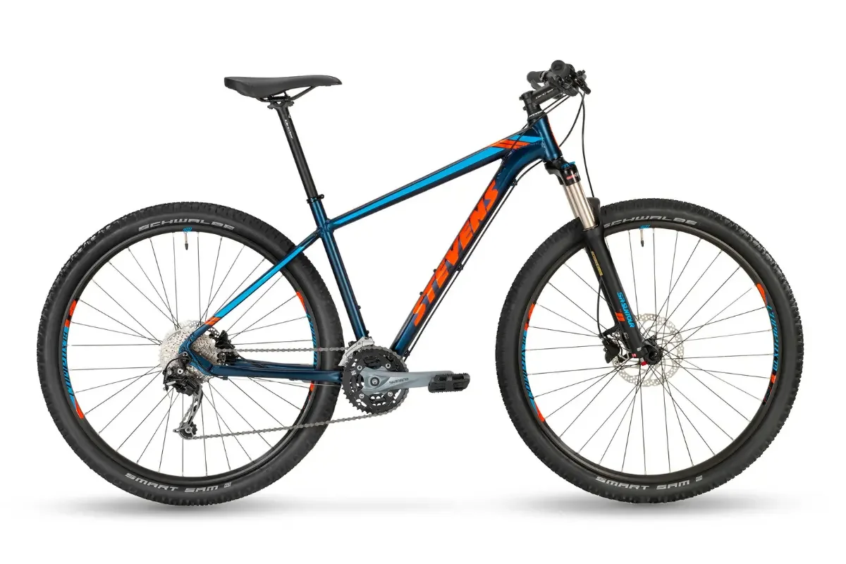 A blue mountain bike with black and orange accents, disc brakes and fat tires.