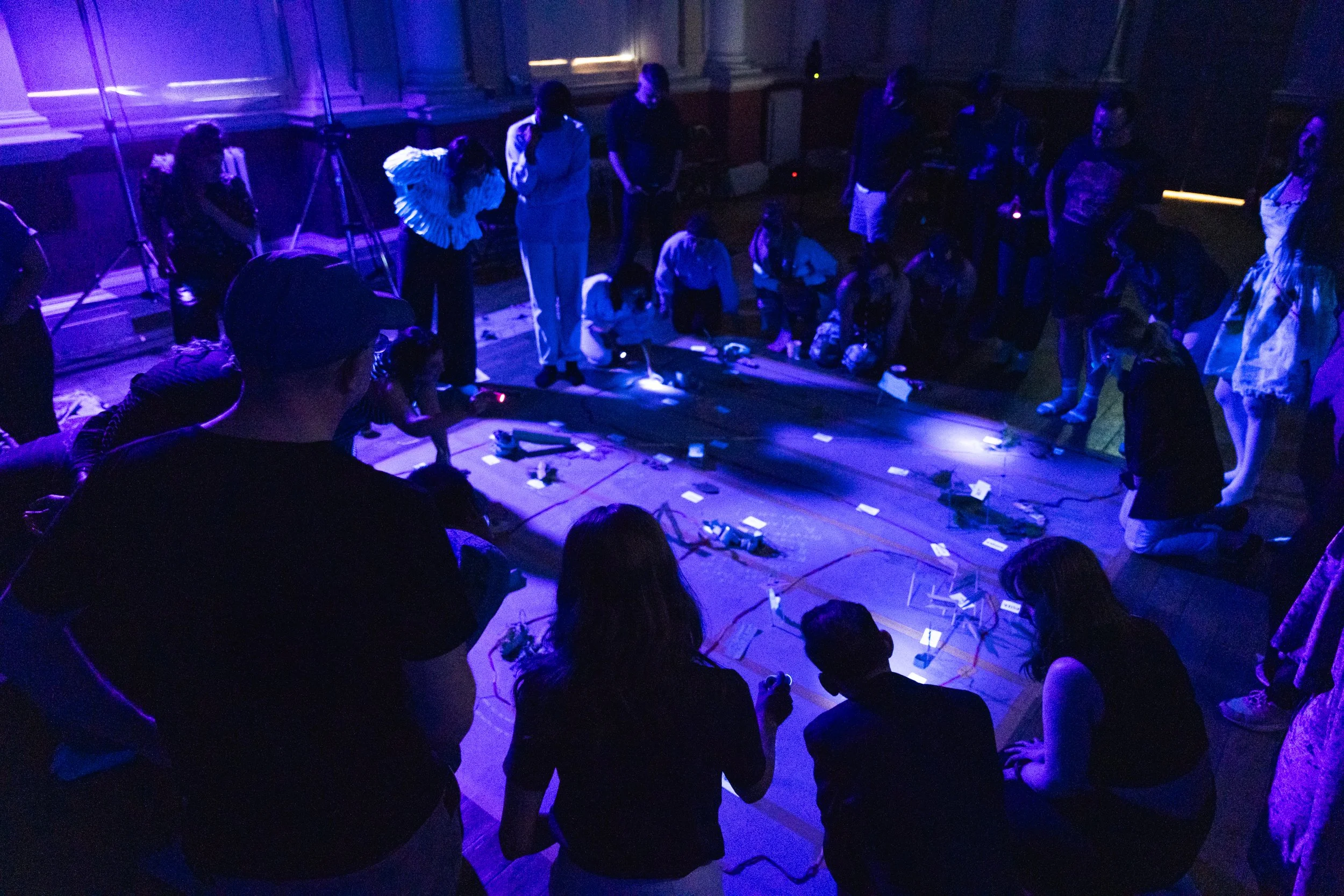 A UV light fills a space with exploring adults